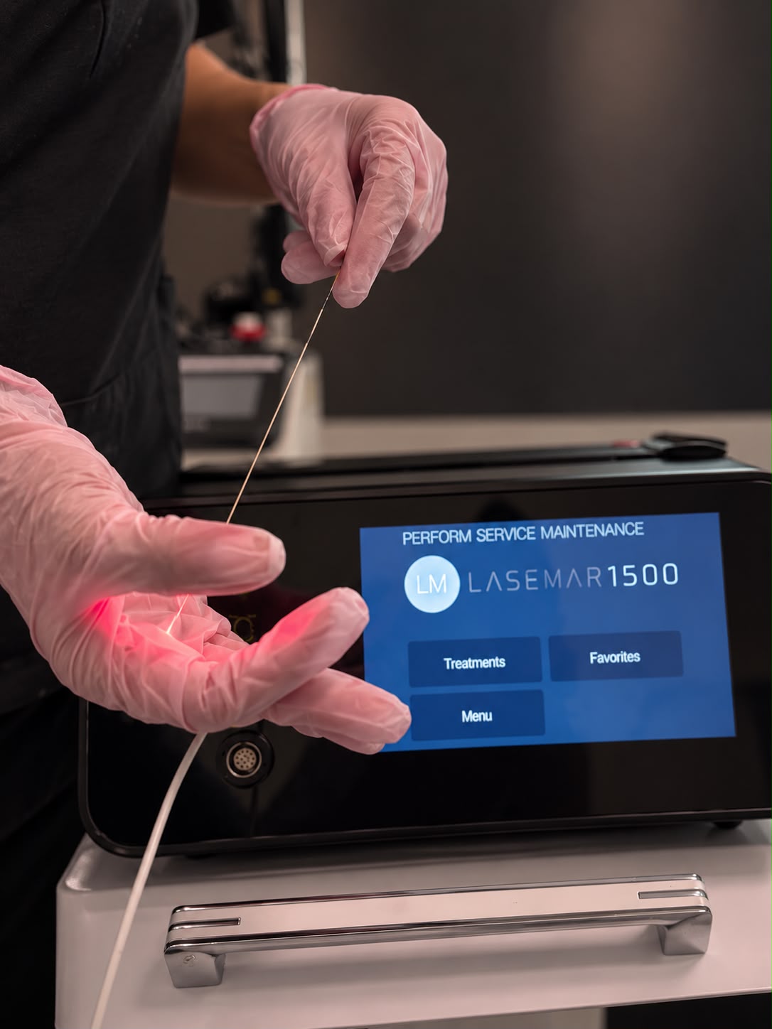 Gloved hands holding the Endolift fibre in front of the laser system